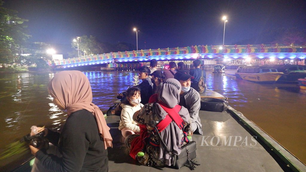 Warga menikmati wisata susur Sungai Martapura di Kota Banjarmasin, Kalimantan Selatan, Rabu (20/4/2022). Wisata susur Sungai Martapura dengan menggunakan kelotok kembali ramai pada malam hari di bulan Ramadhan tahun ini.