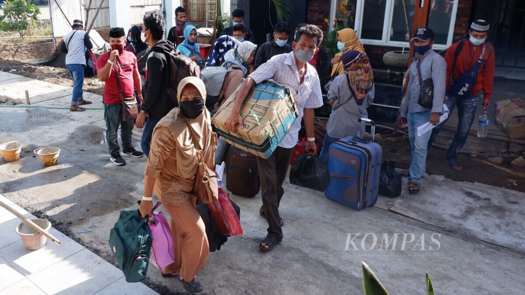 Sejumlah pekerja migran indonesia yang bekerja di Malaysia mengangkut barang setelah tiba di Pelabuhan Tanjung Emas, Kota Semarang, Jawa Tengah, Jumat (15/5/2020). 
