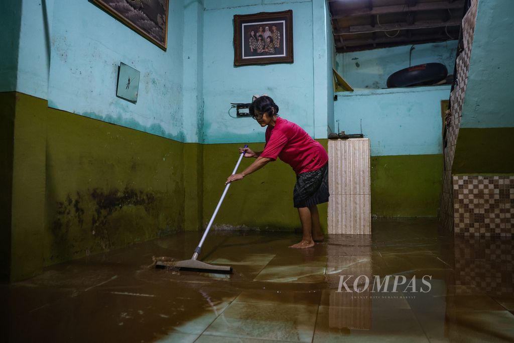 Warga membersihkan rumah dari lumpur sisa banjir di Kampung Melayu, Jatinegara, Jakarta Timur, Jumat (1/12/2023). 