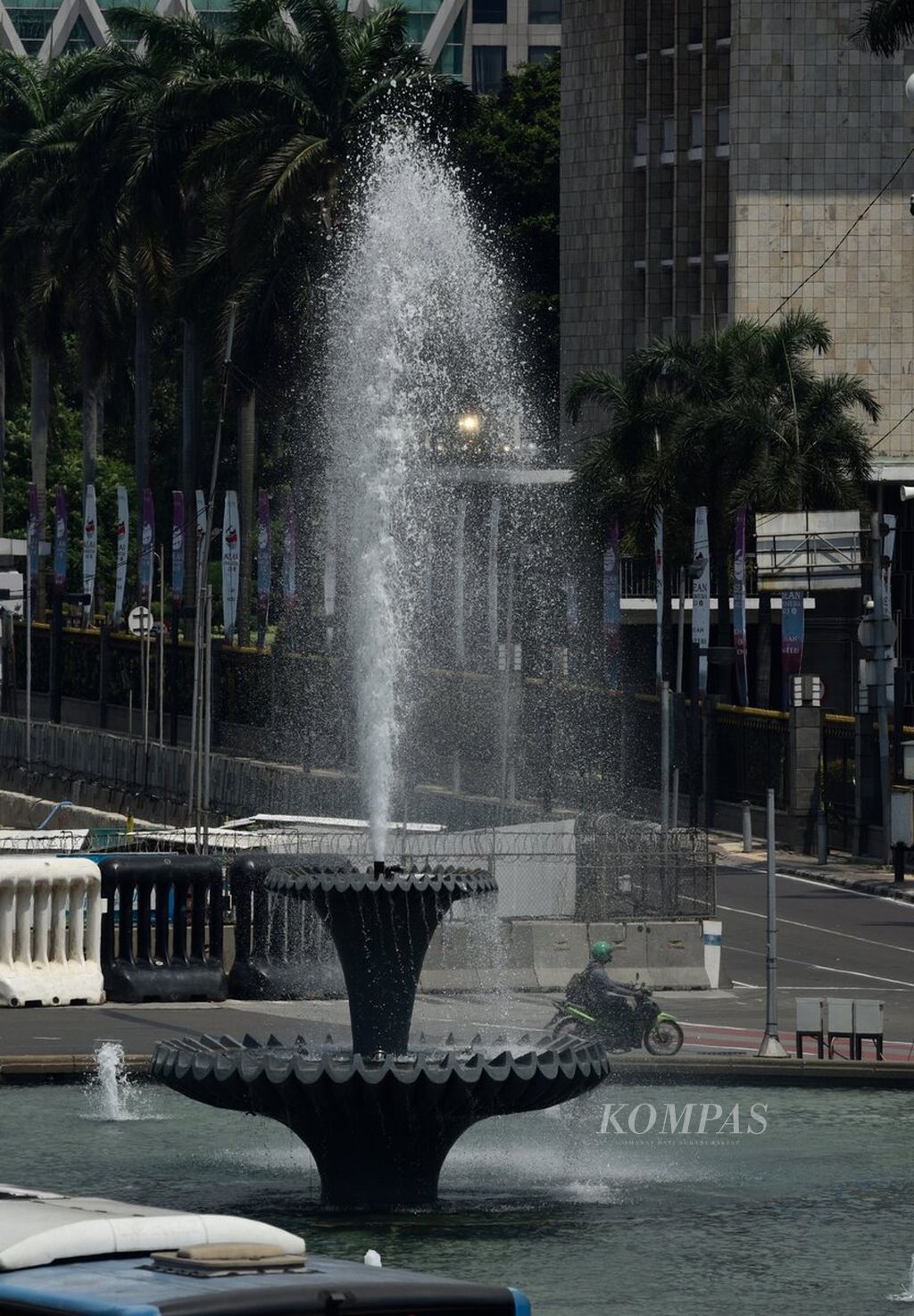 Lalu lintas di kawasan Bundaran Air Mancur Patung Arjuna Wijaya, Jakarta Pusat, Senin (24/4/2023) siang. Beberapa waktu terakhir, cuaca di Jakarta dan wilayah lain terasa panas hingga 35-37,5 derajat celsius pada siang hari. 