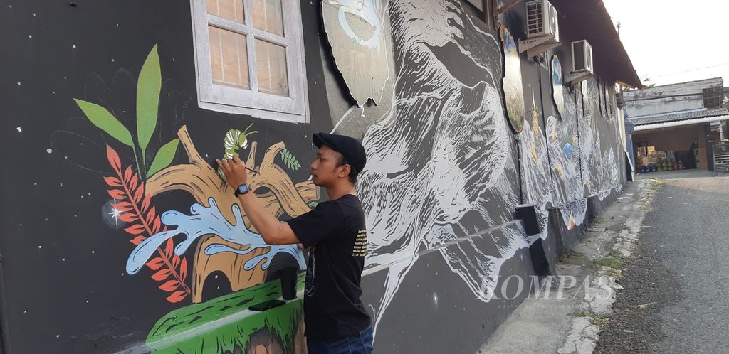 Pelukis disabilitas Supriyono (32) asal Purworejo turut membuat mural Biennale Jogja 17 di area Lohjinawi, Desa Bangunjiwo, Kasihan, Bantul, Rabu (4/10/2023).