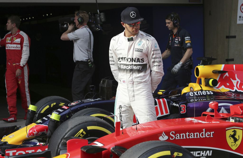 Pebalap Mercedes, Lewis Hamilton, berdiri di samping pebalap Ferrari, Kimi Raikkonen, setelah babak kualifikasi Formula 1 seri China di Sirkuit Internasional Shanghai, China, Sabtu (11/4/2015). Hamilton diyakini akan pindah ke tim Ferrari pada musim 2025.