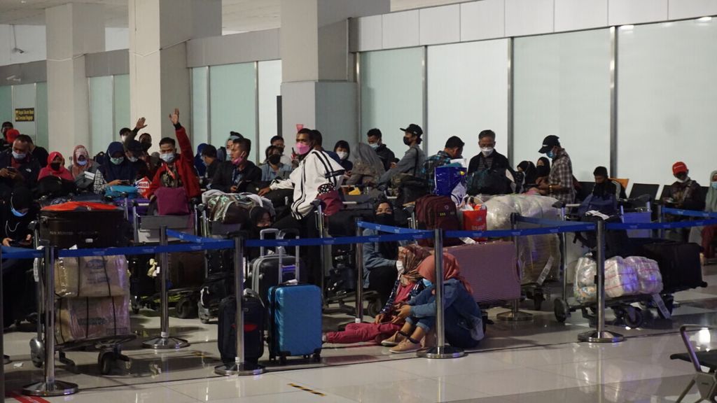 Para penumpang perjalanan luar negeri yang baru tiba di Terminal 3 Bandara Internasional Soekarno-Hatta, Tangerang, Banten, Jumat (24/12/2021), tengah mengantre sebelum diarahkan menuju Rumah Sakit Darurat Covid-19 Wisma Atlet, Jakarta, untuk menjalani karantina.