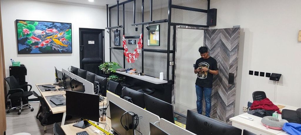 Seorang petugas berpakaian bebas sedang berada di sebuah kantor satelit judi daring di Bekasi Selatan, Bekasi, Jumat (1/11/2024). 11 tersangka ditangkap dalam kasus ini, 10 tersangka di antaranya adalah pegawai Kementerian Komunikasi dan Digital.