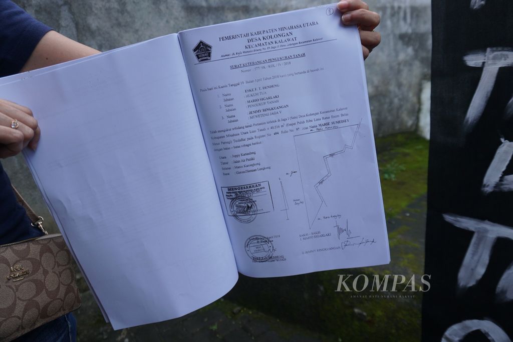 Debbie Sumarauw (51) menunjukkan dokumen peta tanah warisan ibunya, Kamis (19/1/2023), dalam protes di rumah mereka di Kecamatan Kalawat, Minahasa Utara, Sulawesi Utara. Lahan mereka kini telah menjadi bagian dari Bendungan Kuwil Kawangkoan yang diresmikan Presiden Joko Widodo pada hari yang sama.