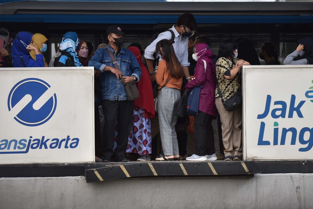 Potret mobilitas pekerja saat antre menunggu kedatangan Bus Transjakarta di Halte Harmoni, Jakarta, Kamis (30/12/2021). Memasuki akhir tahun 2021 ini, pemerintah kembali mengingatkan masyarakat untuk meningkatkan kewaspadaan dengan mengurangi mobilitas akibat ditemukannya transmisi lokal dari varian Omicron. Sejak pertama kali diumumkan pemerintah 16 Desember 2021, kasus Covid-19 varian Omicron di Indonesia telah mencapai 68 hingga Rabu (29/12/2021).