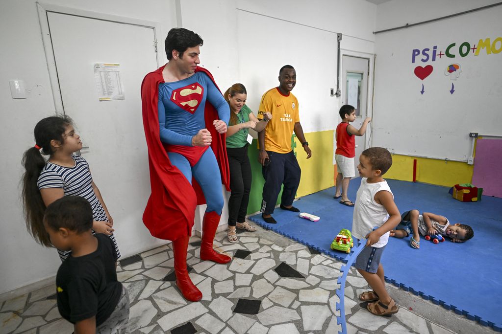 Leonardo Muylaert, dikenal sebagai Superman Brasil, bermain bersama anak-anak di Tijuca, Rio de Janeiro, 18 Maret 2024. 