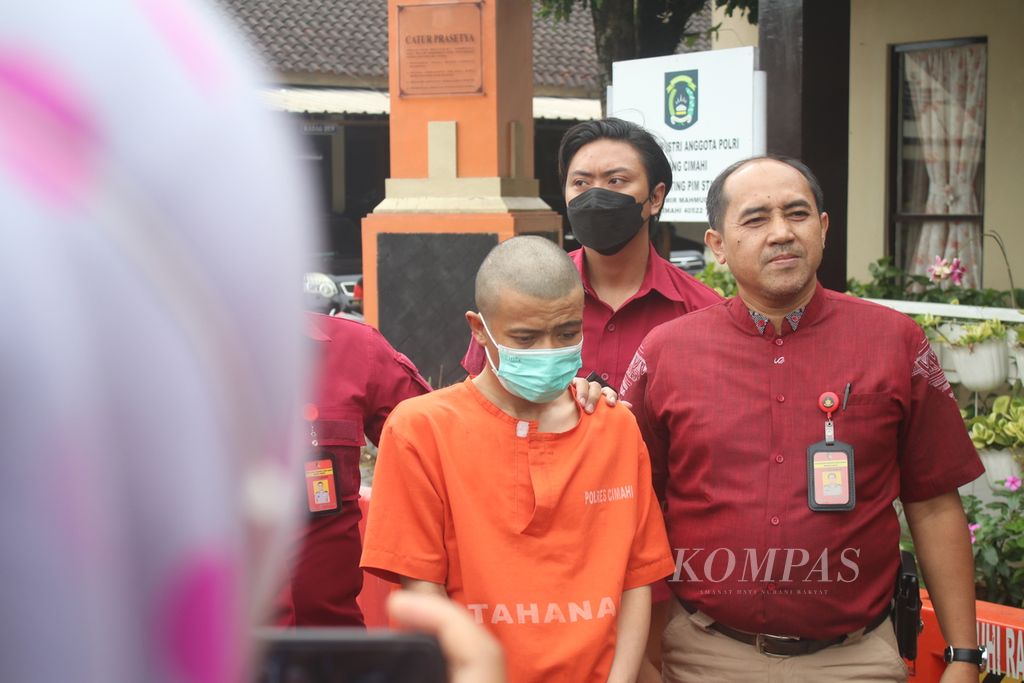 AN (34) digiring polisi di Markas Polres Cimahi, Jawa Barat, Rabu (8/2/2023). Dia diduga menganiaya anaknya hingga tewas. Satu anak lainnya juga dianiaya hingga dirawat di rumah sakit. 