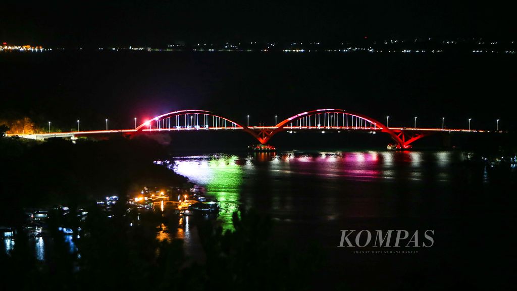 Warna-warni sorot lampu yang menyinari Jembatan Holtekamp atau dikenal dengan sebutan Jembatan Merah Youtefa yang menjadi bagian penghubung Jalan Trans-Papua di Jayapura, Papua, Kamis (30/9/2021).  Warga Jayapura biasa mendatangi kawasan Jembatan Youtefa untuk merayakan malam pergantian tahun.