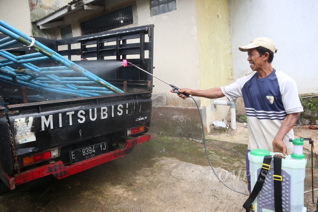 Warga menyemprotkan cairan disinfektan ke mobil pengangkut pakan sapi di Cigugur, Kabupaten Kuningan, Jawa Barat, Kamis (2/6/2022). 