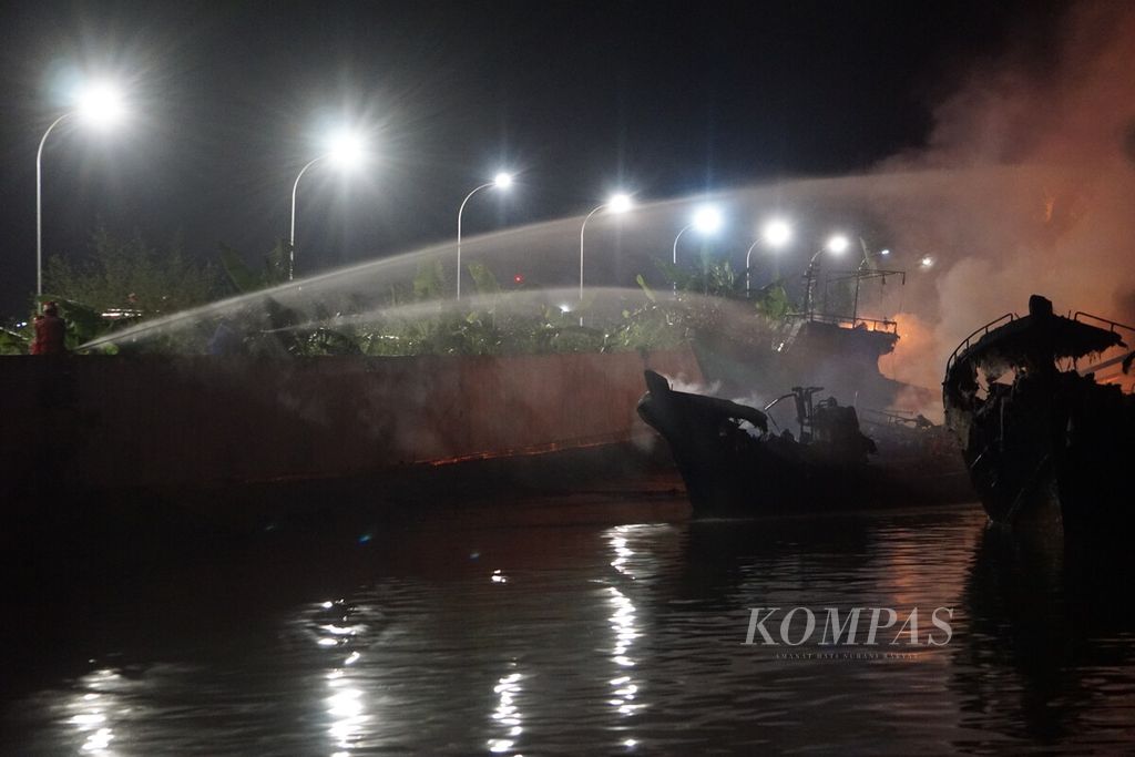 Kobaran api dan kepulan asap kebakaran puluhan kapal di Cilacap, Jawa Tengah masih terus terjadi hingga Selasa (3/5/2022) malam sekitar pukul 23.44 WIB.