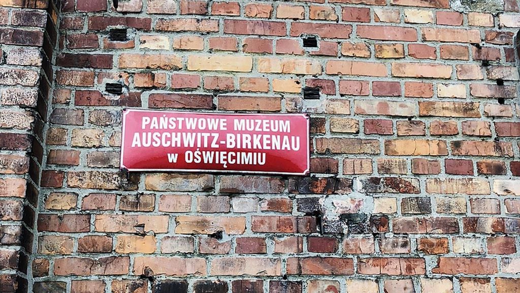 Plakat di dinding gapura utama menjadi penanda kamp konsentrasi Nazi Jerman, Auschwitz Birkenau.