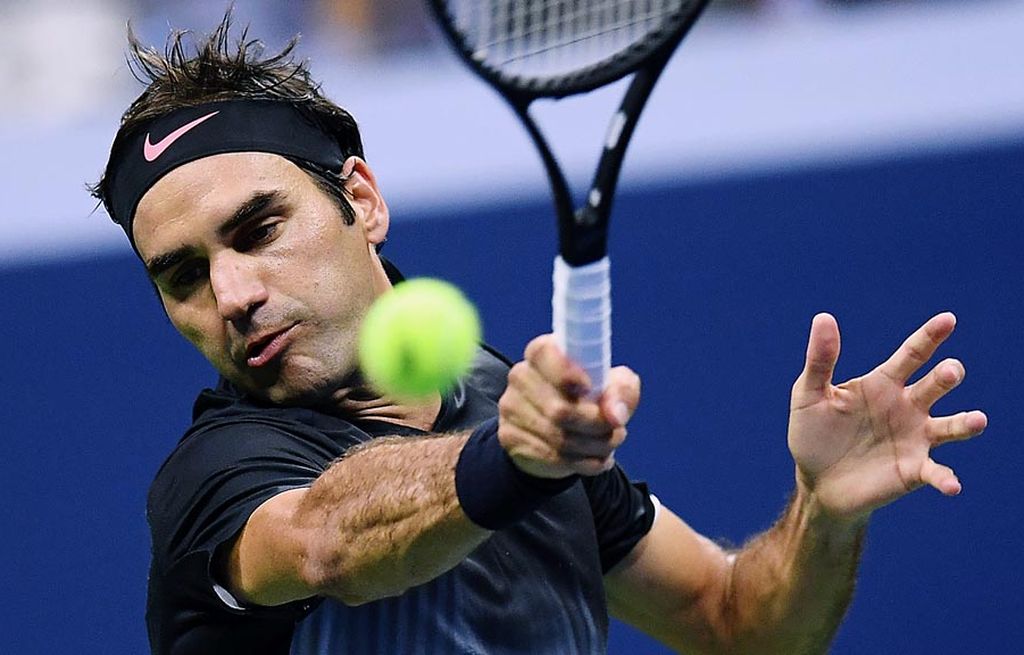 Petenis Swiss, Roger Federer, mengembalikan bola ke area permainan Frances Tiafoe (Amerika Serikat), pada laga babak pertama turnamen AS Terbuka, Rabu (30/8) dini hari WIB. Federer menang 4-6, 6-2, 6-1, 1-6 dan 6-4.