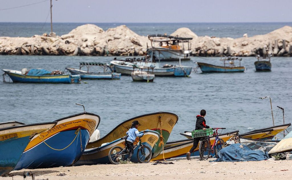 Anak-anak Palestina menuntun sepedanya di pelabuhan nelayan di Kota Gaza, 26 April 2021. 
