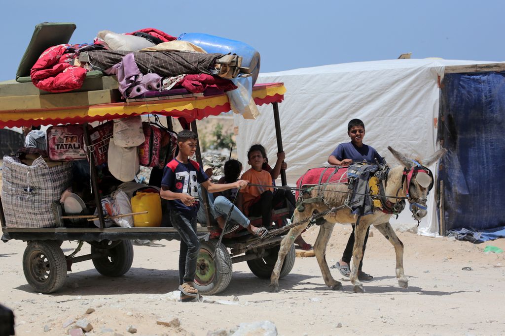 Palestinian children displaced from Rafah, carrying their family belongings on a horse-drawn carriage, arrived in Khan Yunis in the Gaza Strip on Sunday (12/5/2024).