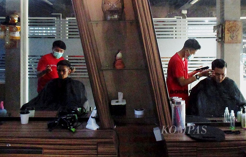 Dua  karyawan Chiganoz Barbershop  melayani  pelanggan di outlet Chiganoz, Denpasar, Jumat (21/7) sore. Bisnis jasa pangkas rambut pria semakin marak  di Kota Denpasar. Pelanggan mendapat pelayanan eksklusif, seperti konsultasi gaya rambut, cuci rambut, pemijatan, dan mendapatkan pomade untuk kerapian rambut. Harganya bervariasi mulai dari Rp 25.000 per orang.