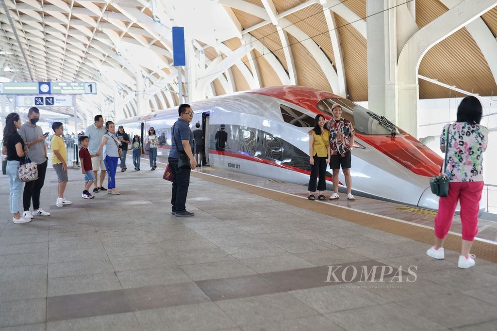 Warga berpose di depan kereta cepat di Stasiun Kereta Cepat Halim, Jakarta, Minggu (7/4/2024). PT Kereta Cepat Indonesia China (KCIC) mengoperasikan sebanyak 52 perjalanan Whoosh per hari selama masa libur Lebaran. Penambahan ini dimulai dari tanggal 3 sampai 18 April 2024. Menjelang Lebaran terdapat kenaikan penumpang hingga 10 persen. Tercatat pada H-4 Idul Fitri 1445 Hijriah atau 6 April 2024, penumpang mencapai 1.500 pengguna. 