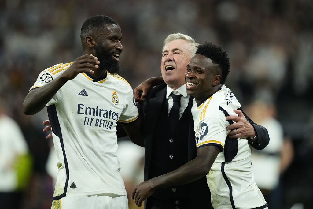 Pelatih Carlo Ancelotti (tengah) merayakan kemenangan bersama Vinicius Junior (kanan) dan Antonio Rudiger setelah mengalahkan Bayern Munich dalam semifinal Liga Champions League, Rabu (8/5/2024).