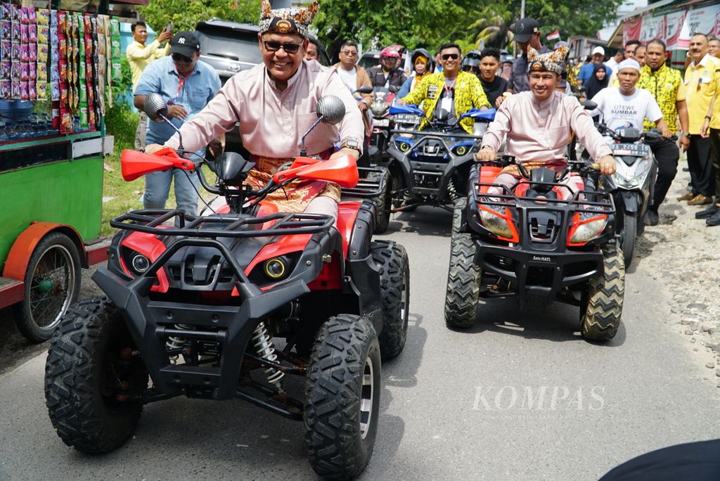 Bakal pasangan calon gubernur dan wakil gubernur Sumatera Barat, Epyardi Asda (kiri) dan Ekos Albar (kanan), mengendarai ATV untuk mendaftar ke KPU Sumbar di Kota Padang, Kamis (29/8/2024). 