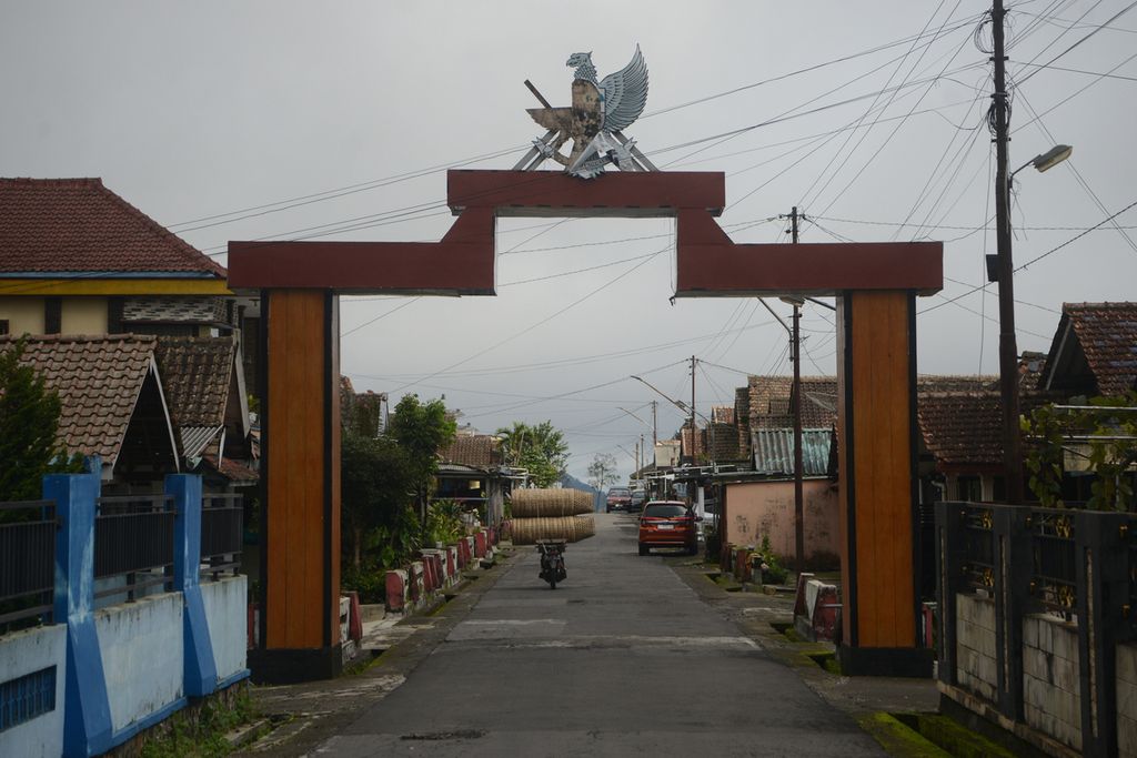 Penjual keranjang memasuki gerbang di Dusun Merapisari, Desa Ngablak, Kecamatan Ngablak, Magelang, Jawa Tengah, Jumat (2/2/2024). Dusun itu mulai ditempati oleh warga lereng Gunung Merapi yang mengungsi pada tahun 1954 untuk menghindari bahaya erupsi. 