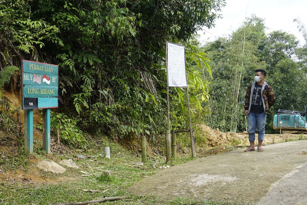 Willeon (19), warga negara Indonesia, berhenti di depan papan perbatasan Indonesia-Malaysia di wilayah Long Midang, Desa Pa'nado, Kecamatan Krayan, Kabupaten Nunukan, Kalimantan Utara, Senin (29/11/2021).