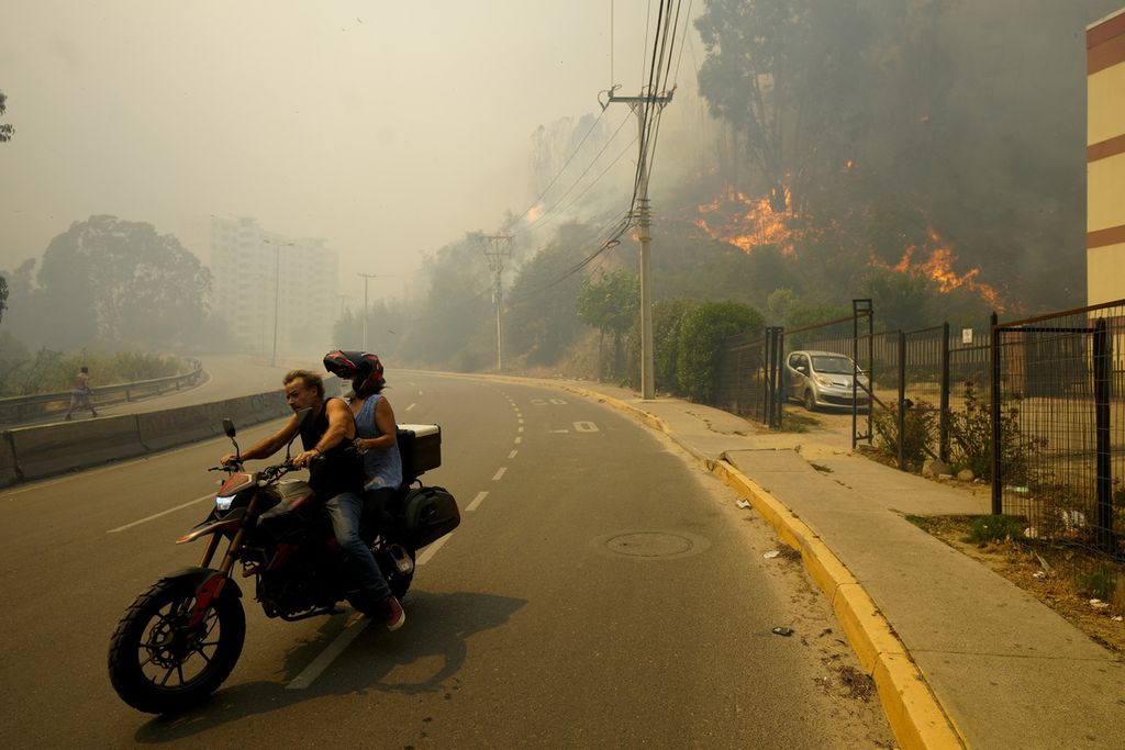 Warga mengungsi di tengah kebakaran hutan dan lahan di Vina del Mar, Chile, Minggu (3/2/2024). 