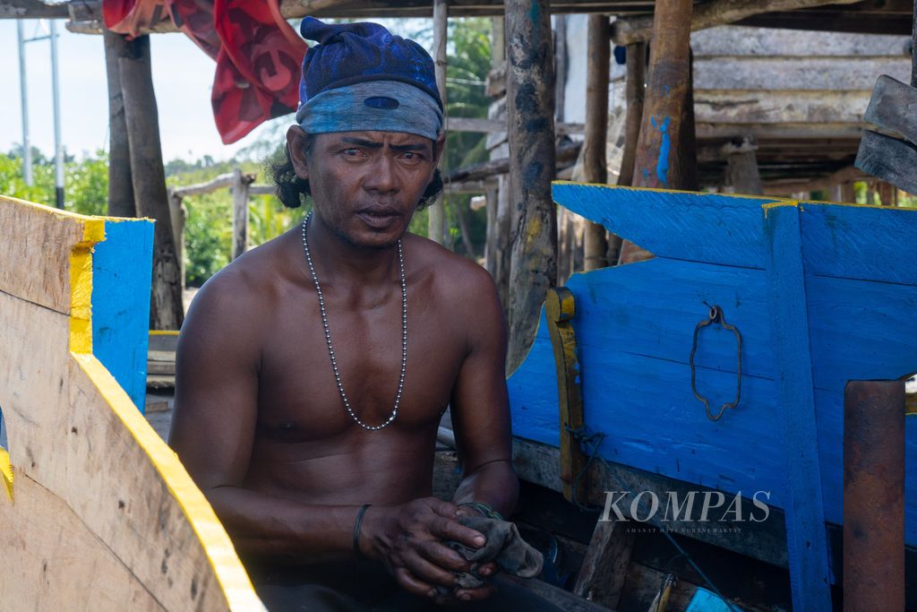 Warga suku Laut, Aan, memperbaiki mesin kapal yang rusak di Kampung Air Bingkai, Desa Tajur Biru, Kecamatan Temiang Pesisir, Kabupaten Lingga, Kepulauan Riau, Minggu (17/7/2022).
