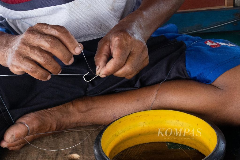 Seorang nelayan menyiapkan mata pancing untuk menangkap ikan tongkol di perairan yang berjarak sekitar 45 kilometer di sebelah timur Pulau Natuna Besar, Kepulauan Riau, Sabtu (26/3/2022).