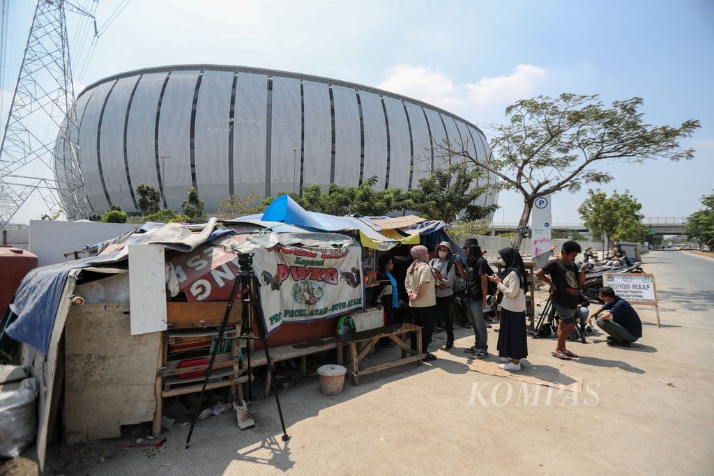 Wartawan mewawancarai warga Kampung Bayam di depan tenda yang didirikan di depan pintu barat Jakarta International Stadium (JIS), Jakarta Utara, Jumat (22/9/2023).