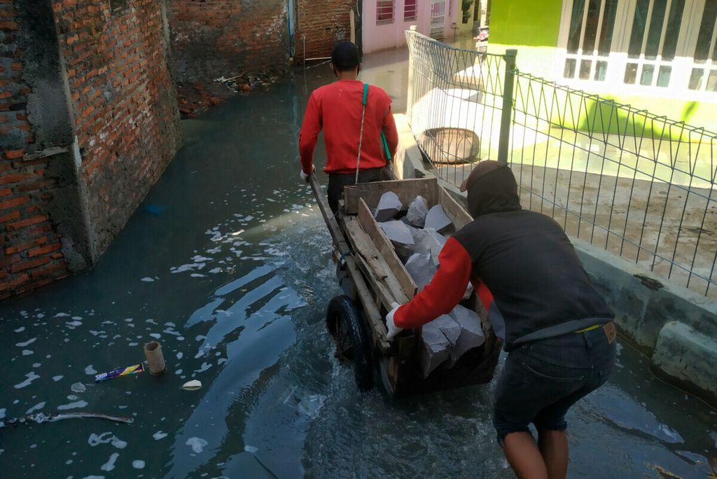 Warga membawa material batu untuk membuat tanggul untuk mencegah limpasan air laut di Tambaklorok, Kota Semarang, Jawa Tengah, Sabtu (24/7/2021). Tanggul laut menjadi salah satu usaha yang dilakukan untuk mengurangi dampak banjir di sekitar permukiman warga.