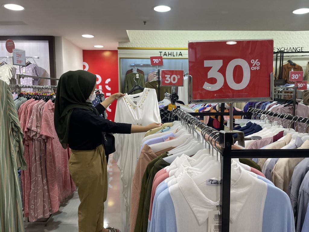 Seorang pengunjung memilih baju yang ditawarkan dengan potongan harga di Mal Plaza Blok M, Jakarta Selatan, Rabu (12/4/2023).