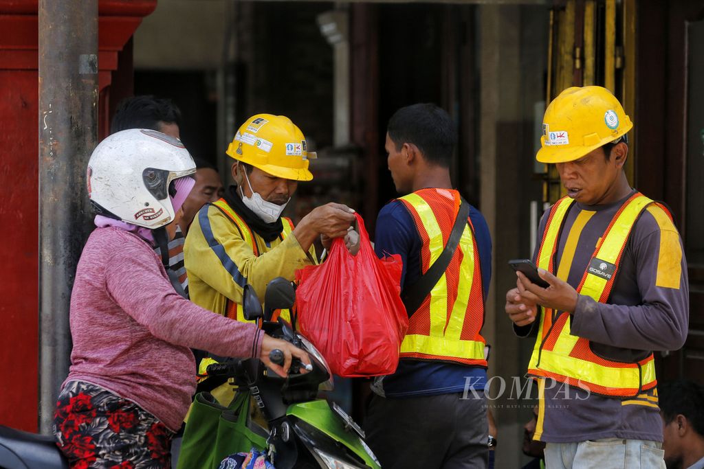 Pekerja pembangunan jalur MRT sedang memesan makanan saat isitrahat siang di kawasan Glodok, Jakarta, Minggu (20/11/2022).