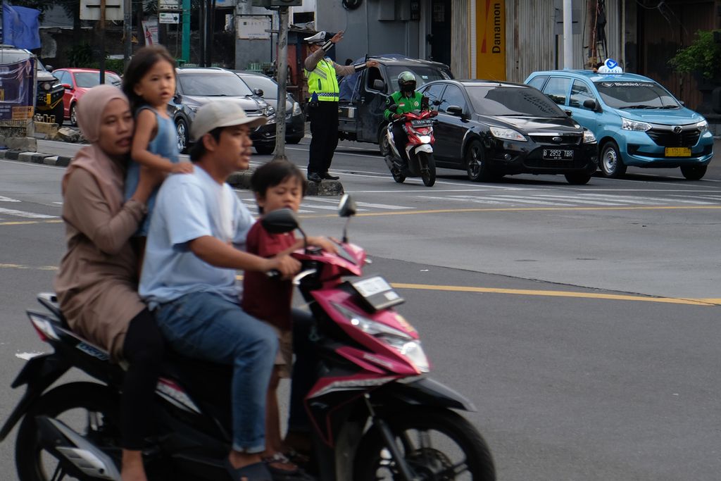 Pengendara sepeda motor tidak menggunakan helm dan melebihi kapasitas penumpang melintas di Jalan Mampang Prapatan, Jakarta Selatan, Minggu (20/11/2022). 