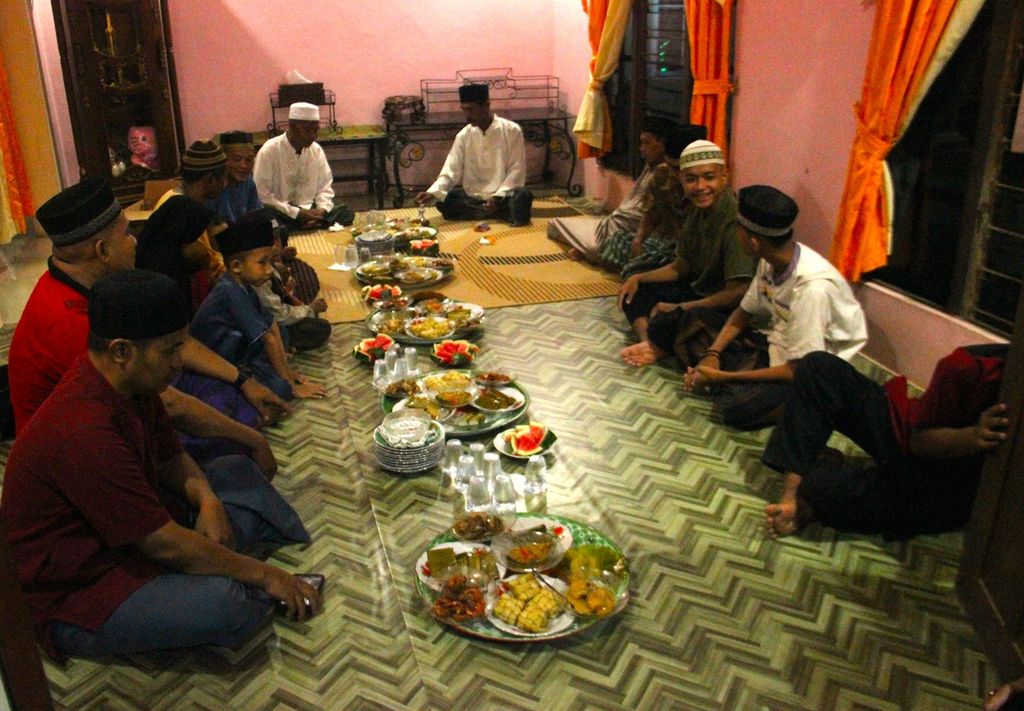 Warga berkumpul untuk makan bersama di salah satu rumah di Dusun Lima, Desa Pal Sembilan, Kecamatan Sungai Kakap, Kabupaten Kubu Raya, Kalimantan Barat, saat malam Takbiran pada Minggu (1/5/2022) malam. 