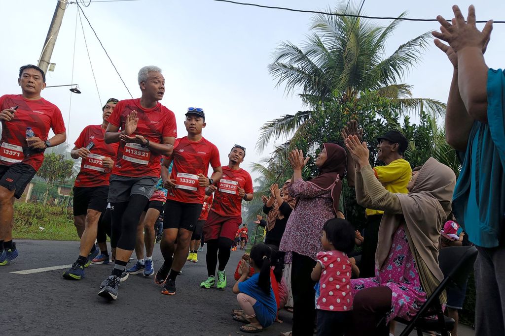 Gubernur Jawa Tengah Ganjar Pranowo menyapa warga yang memberikan semangat dalam Borobudur Marathon 2022 Powered by Bank Jateng kategori Tilik Candi di Magelang, Jawa Tengah, Minggu (12/11/2022).