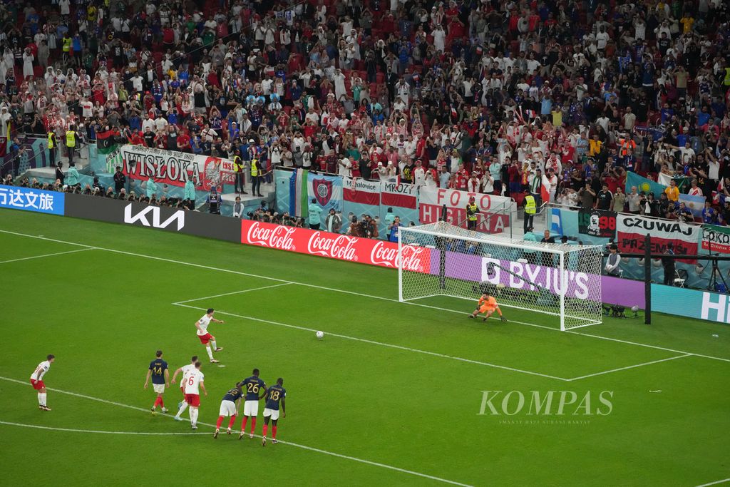 Pemain Polandia, Robert Lewandowski, mencetak gol penalti dalam pertandingan melawan Perancis di babak 16 besar Piala Dunia 2022 di Stadion Al Thumama, Qatar, Minggu (4/12/2022). Mbappe mencetak dua gol dalam pertandingan dan membantu Perancis mengalahkan Polandia 3-1. 