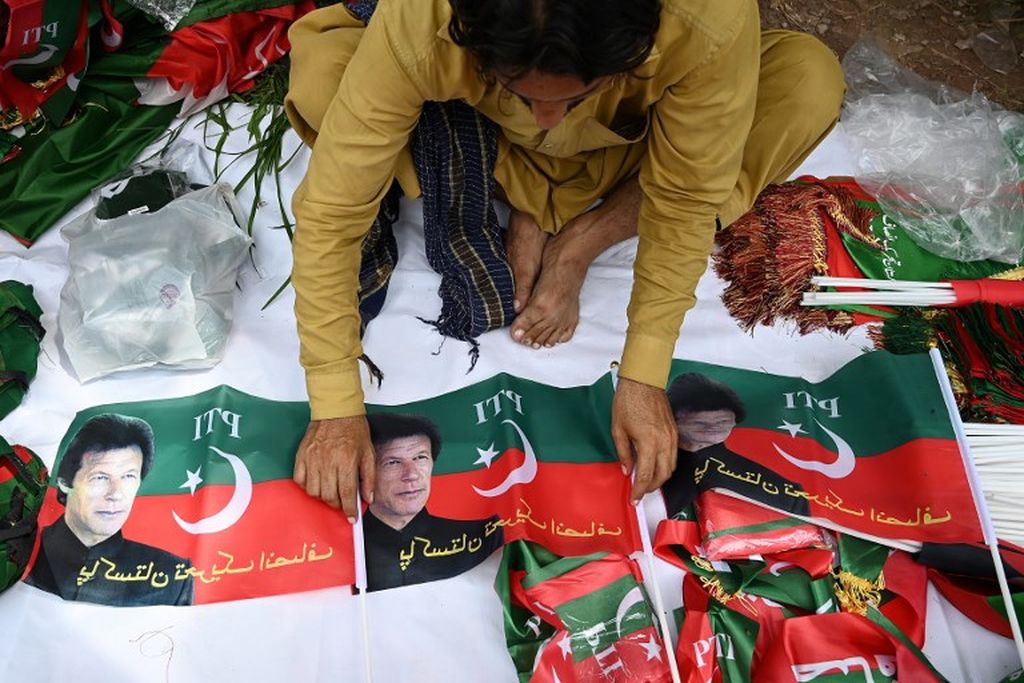 Seorang warga menjual bendera partai Pakistan Tehreek-e-Insaf (PTI) yang menggambarkan mantan perdana menteri Pakistan Imran Khan, di luar kediaman Khan di Islamabad pada 22 Agustus 2022. 