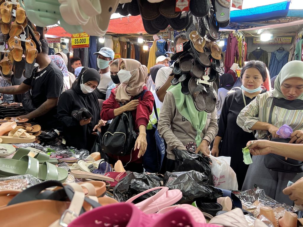 Sejumlah pembeli saat memilih sandal di Pasar Tanah Abang, Jakarta Pusat, Sabtu (8/4/2023).