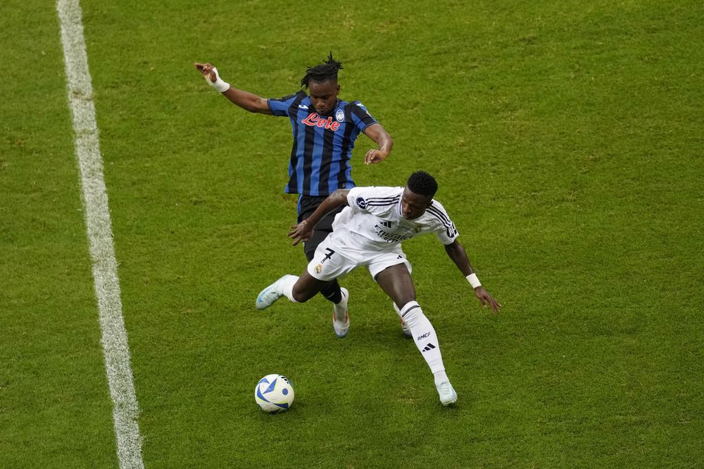 Pemain Real Madrid, Vinicius Junior (kanan), berebut bola dengan pemain Atalanta, Ademola Lookman, pada laga final Piala Super Eropa di Stadion Narodowy, Warsawa, Polandia, Rabu (14/8/2024). Real Madrid menang dengan skor 2-0.