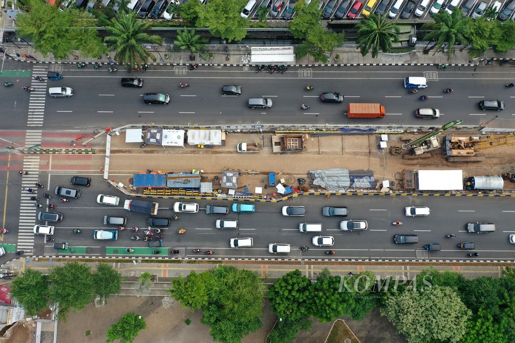 Foto udara kendaraan melintasi pekerjaan konstruksi kereta ringan (LRT) Jakarta fase 1B Velodrome-Manggarai terhenti sementara saat libur Tahun Baru di Jalan Pemuda, Jakarta Timur, Senin (1/1/2024).