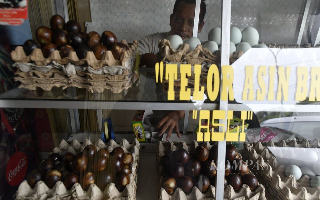 Penjual telur asin menyiapkan pesanan pelanggan di salah satu kios yang menjual telur asin di Jalan Gajah Mada, Kabupaten Brebes, Jawa Tengah, Kamis (21/4/2022). Para pelaku usaha mikro, kecil, dan menengah di sepanjang jalur pantai utara (pantura) Jawa Tengah seperti para penjual telur asin Brebes ini mesti berusaha keras untuk tetap bertahan. Setelah mengalami kemerosotan pembeli sejak beroperasinya Jalan Tol Cipali pada 2015 lalu, dalam dua tahun terakhir pandemi Covid-19 semakin menambah usaha mereka kian sulit.