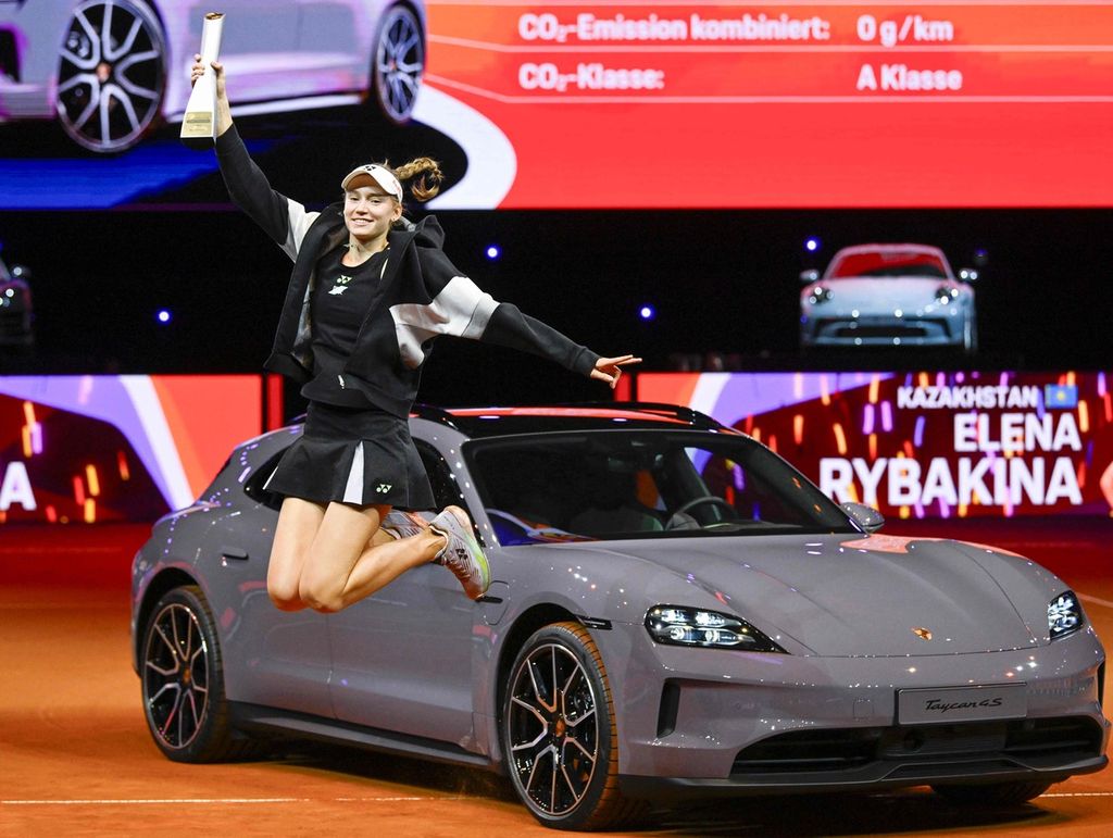 Petenis Kazakhstan Elena Rybakina berpose di depan mobil Porsche Taycan 4S Sport Turismo sebagai hadiah juara turnamen WTA 500 Stuttgart setelah mengalahkan Marta Kostyuk di final, Minggu (21/4/2024) di Stuttgart, Jerman. Rybakina menang atas Kostyuk, 6-2, 6-2. 