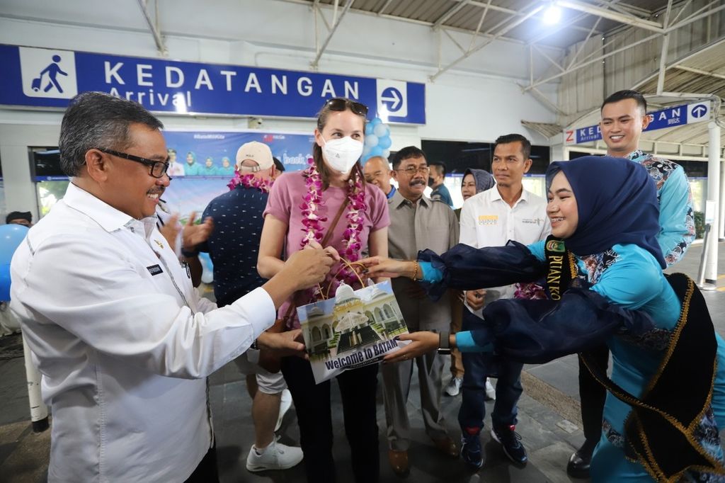 Sekretaris Daerah Kota Batam Jefridin (kiri) menyambut seorang wisatawan mancanegara yang datang di Pelabuhan Batam Centre, Kota Batam, Kepulauan Riau, Rabu (15/6/2022).