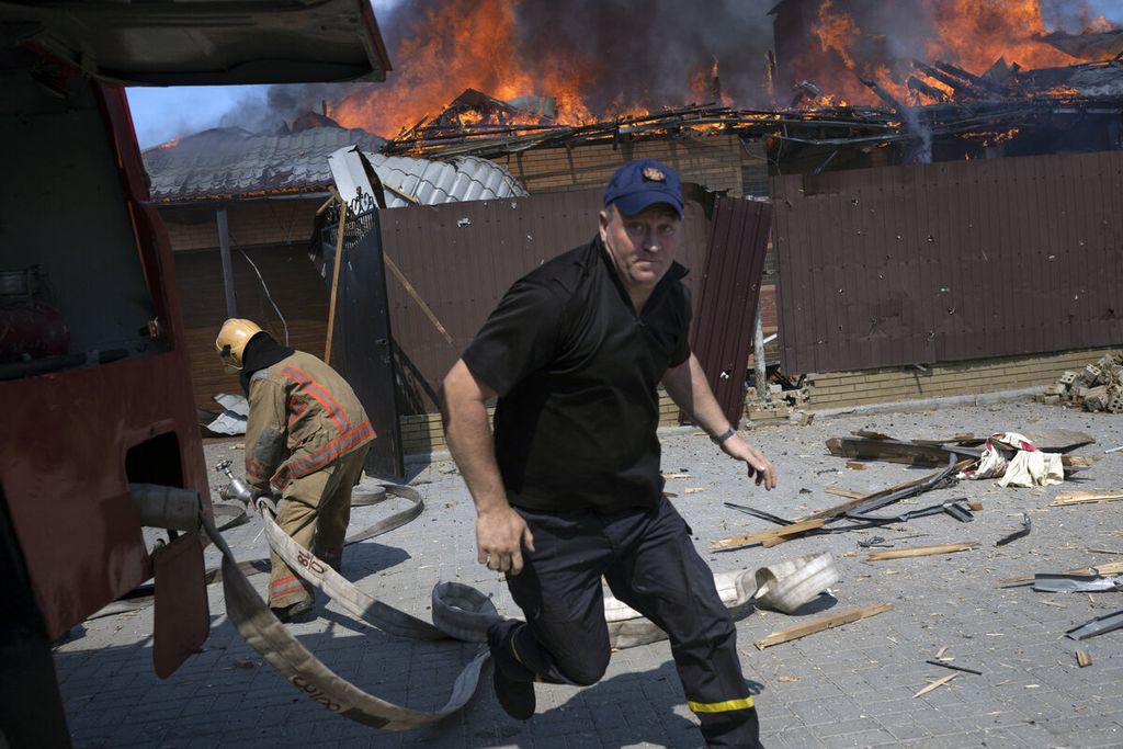 Petugas pemadam kebakaran berusaha memadamkan api yang membakar sebuah rumah setelah terjadi serangan dari Rusia di Bakhmut, Ukraina, Rabu (27/7/2022). 