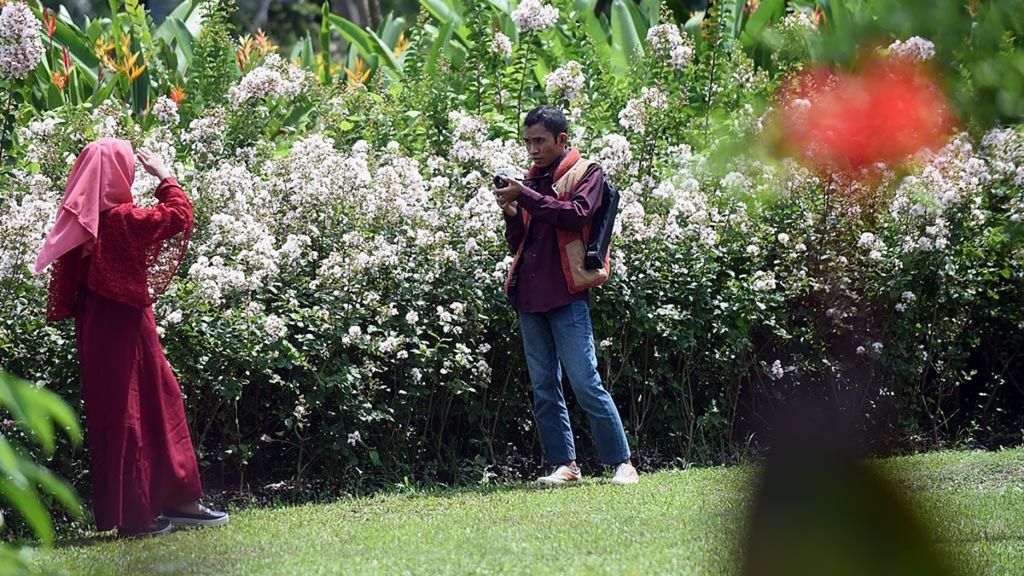 Pengunjung menikmati keindahan Taman Harmoni, Surabaya, Sabtu (2/2/2019). Taman Harmoni yang ditanami berankaragama bunga tersebut dibangun di lahan yang sebelumnya tempat pembuangan akhir.
