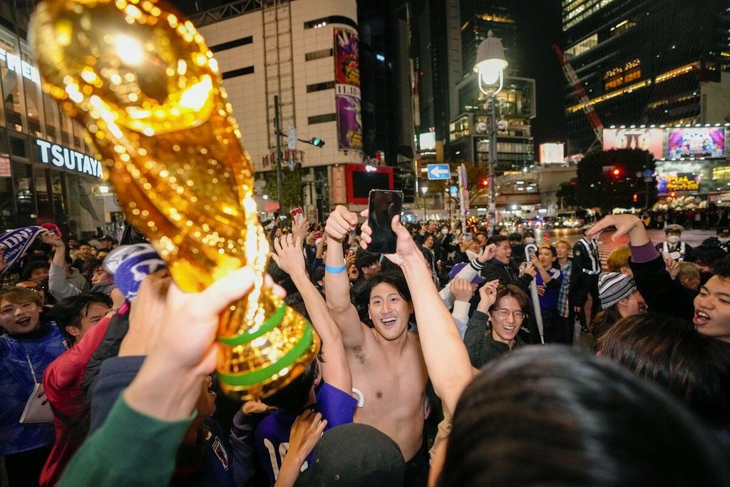 Warga Jepang merayakan kemenangan tim nasional Jepang atas Jerman dalam penyisihan Grup E Piala Dunia Qatar di persimpangan Shibuya, Tokyo, Jepang, Kamis (24/11/2022). Jepang secara mengejutkan mengalahkan Jerman, 2-1.