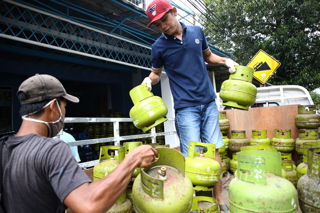 Pekerja menurunkan tabung elpiji 3 kilogram kosong di agen elpiji di kawasan Jagakarsa, Jakarta Selatan, Rabu (10/2/2021).