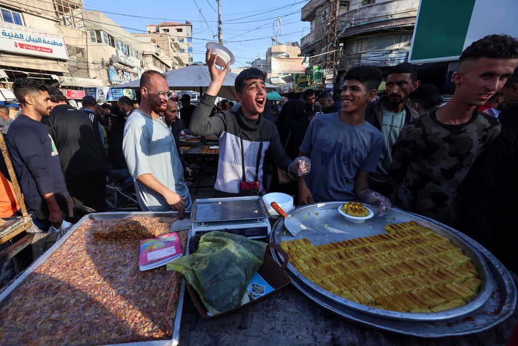 Warga Palestina menjual manisan di Rafah di Jalur Gaza selatan pada Selasa (9/4/2024), sehari menjelang Idul Fitri. 