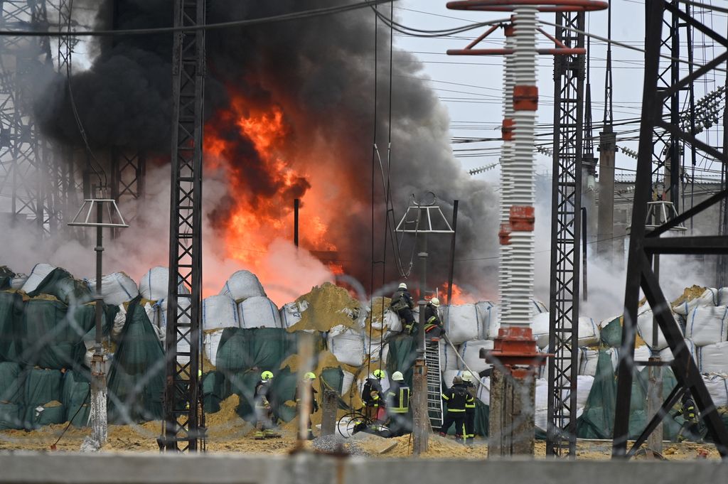 Petugas pemadam kebakaran mencoba memadamkan api yang berkobar di salah satu fasilitas jaringan listrik di Kharkiv, Ukraina, Jumat (22/3/2024), akibat serangan rudal militer Rusia. 