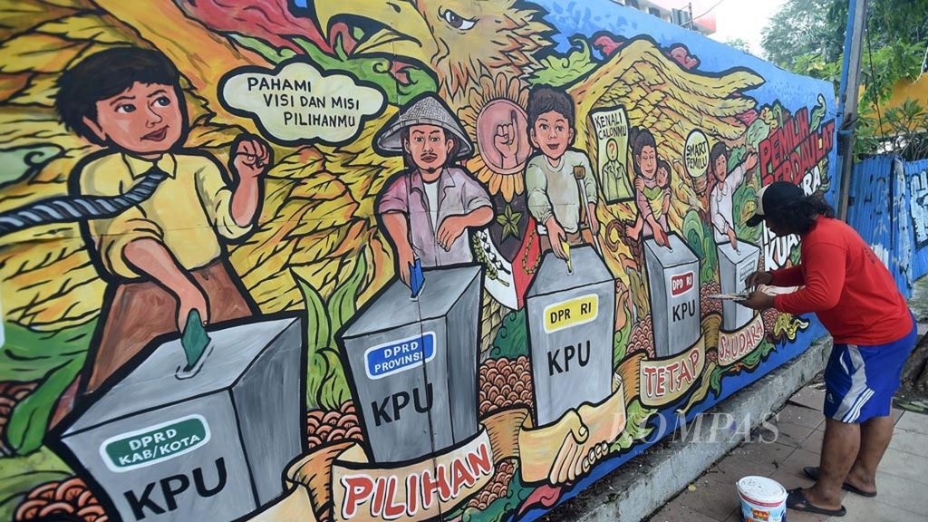 Seniman Mural Subki menyelesaikan mural bertema partisipasi warga dalam Pemilu 2019 saat mengikuti lomba mural di Jalan Pemuda, Surabaya, Rabu (3/4/2019).
